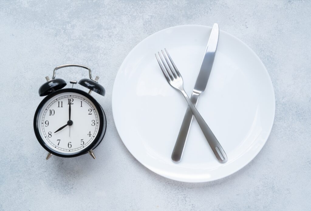 Plate with utensils by a clock